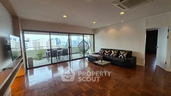 Spacious living room with city view and large balcony access.