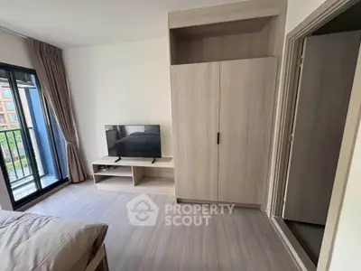 Modern bedroom with balcony access and sleek wooden furniture in a stylish apartment.