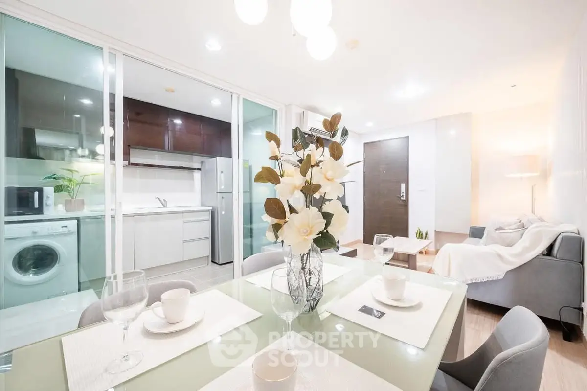 Modern open-plan living room and kitchen with elegant decor and appliances.