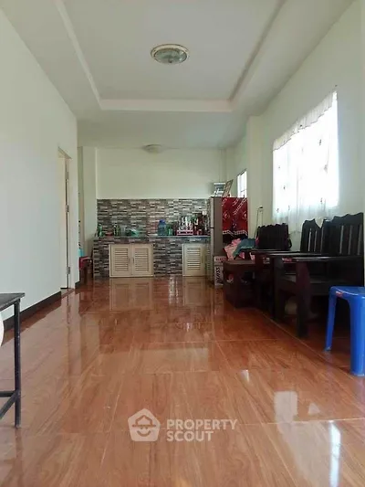 Spacious living area with wooden flooring and open kitchen layout