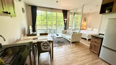 Spacious open-plan living room with large windows and modern kitchen in a stylish apartment.