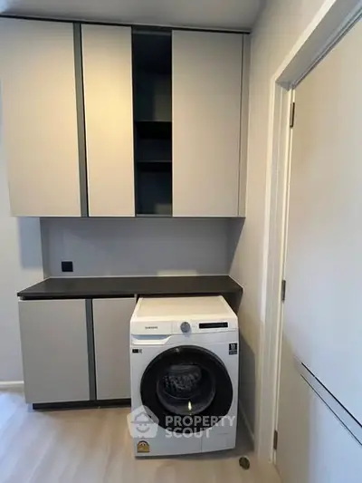 Modern laundry area with sleek cabinetry and washing machine