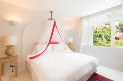 Bright and airy bedroom with canopy bed and large window view