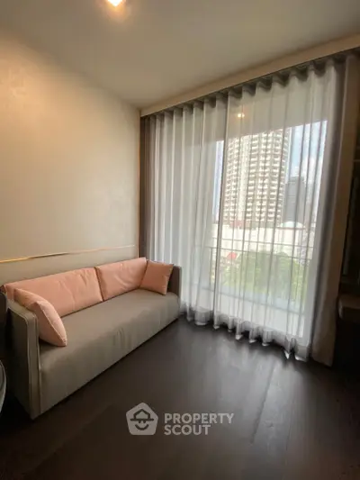 Modern living room with elegant sofa and floor-to-ceiling windows offering city view.