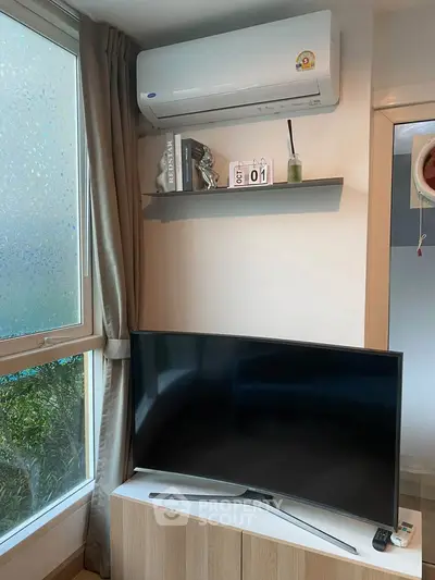 Modern living room corner with air conditioner and flat-screen TV, perfect for cozy relaxation.