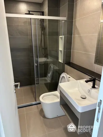 Modern bathroom with sleek shower and stylish fixtures in contemporary apartment.