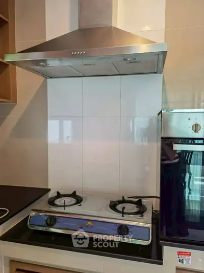 Modern kitchen with gas stove and stainless steel range hood