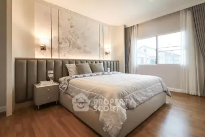 Luxurious bedroom with elegant decor and large window offering natural light