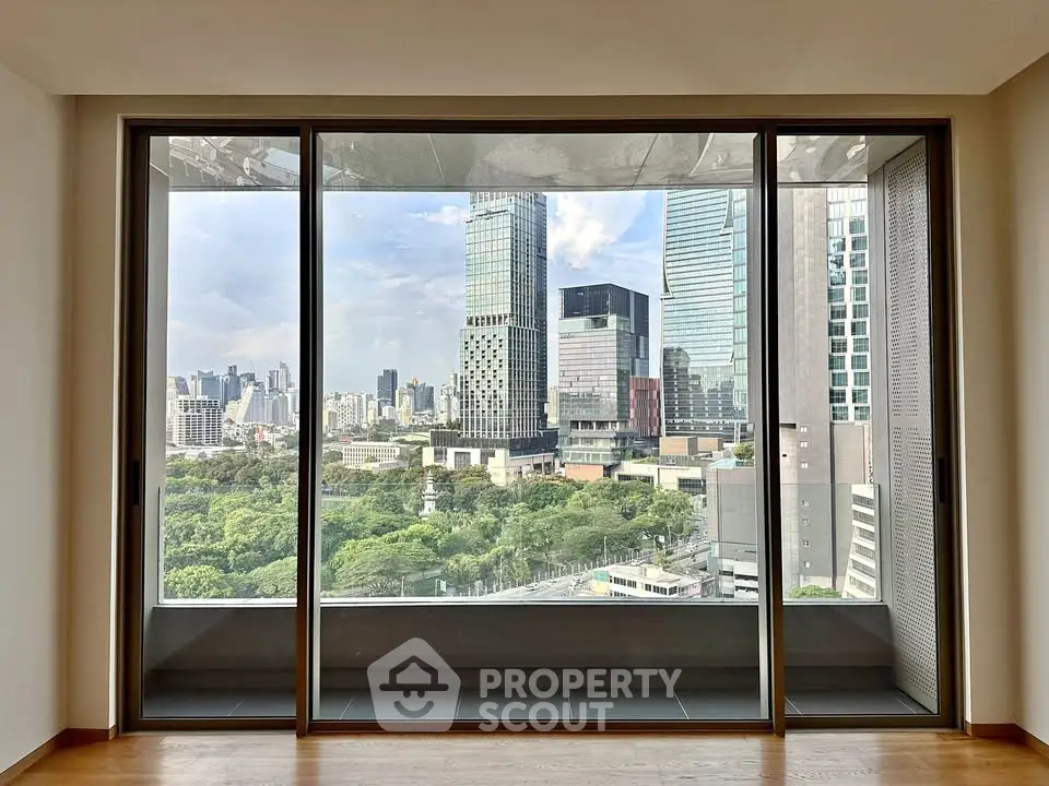 Stunning cityscape view from modern apartment window with lush greenery and skyscrapers.