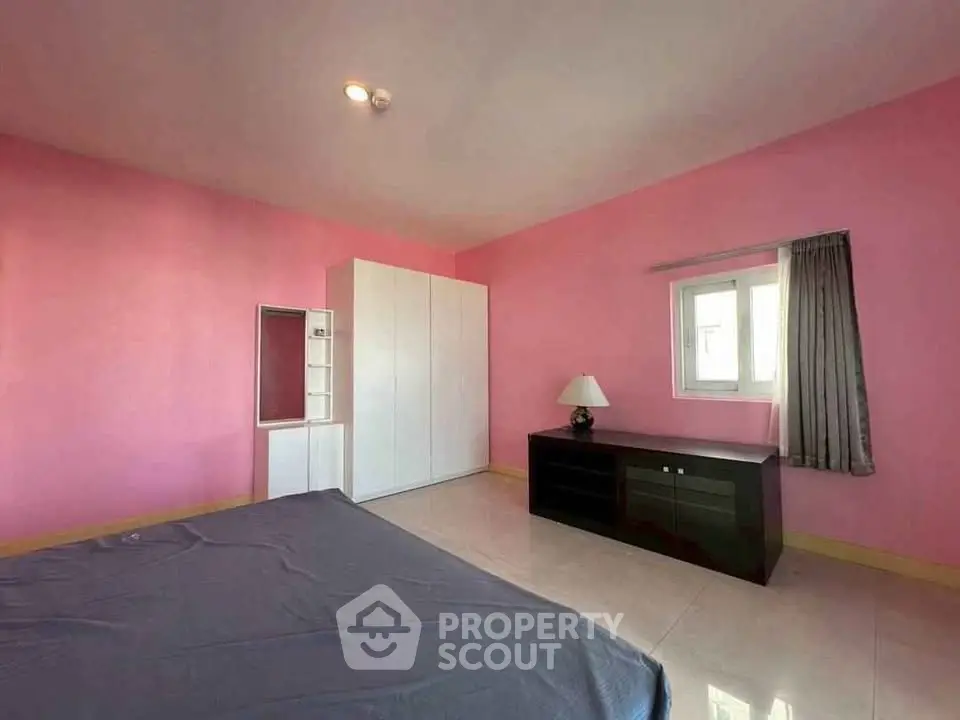 Spacious bedroom with pink walls and modern furniture