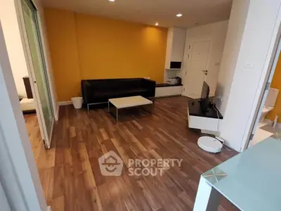 Modern living room with wooden flooring and vibrant yellow accent wall