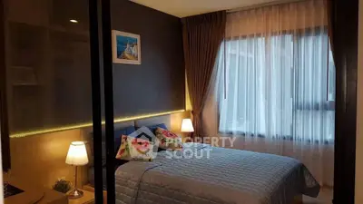 Cozy bedroom with large window and stylish decor in modern apartment.