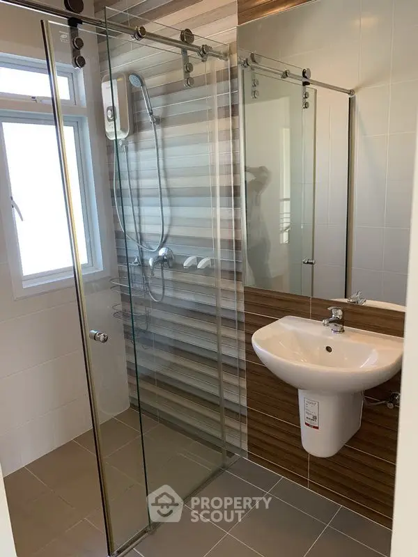 Modern bathroom with glass shower enclosure and stylish wall tiles