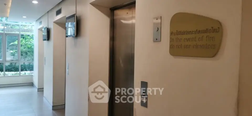 Modern building elevator lobby with safety signage and natural light