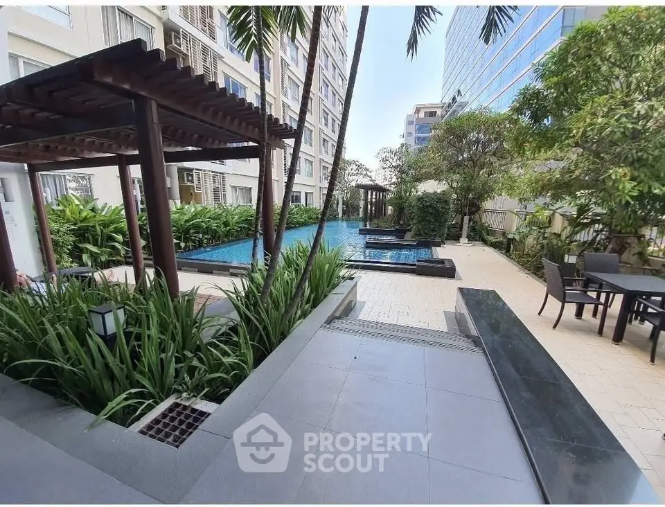 Luxurious apartment complex with pool and lush garden area, perfect for relaxation and leisure.