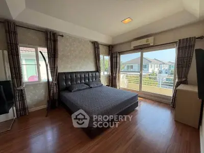 Spacious bedroom with large windows and modern decor, offering a bright and inviting atmosphere.