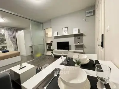 Modern open-plan living room with dining area and bedroom in cozy apartment.