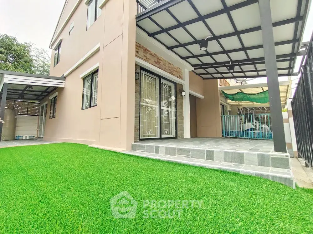 Modern home exterior with artificial grass and covered patio area