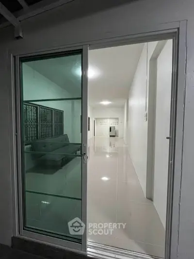 Modern apartment with sleek sliding glass door and spacious interior view.
