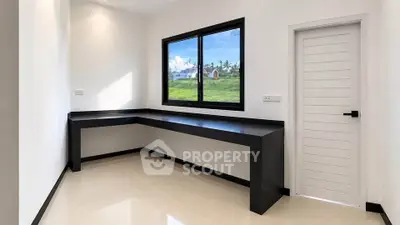 Modern study room with large window and sleek black desk overlooking greenery.