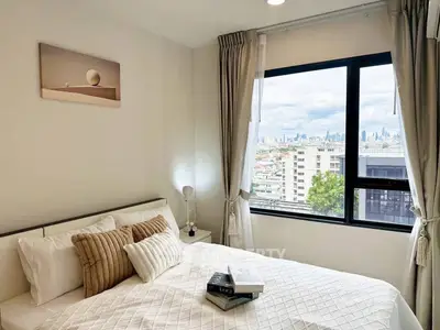 Cozy bedroom with city view, modern decor, and natural light