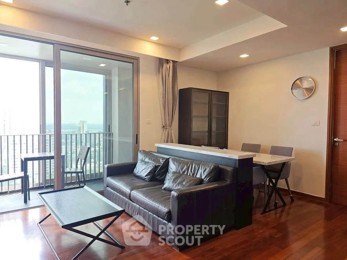 Modern living room with sleek furniture and city view balcony in luxury apartment.