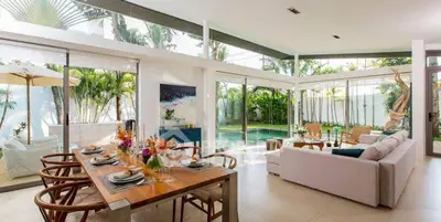 Luxurious open-plan living room with pool view and elegant dining area, perfect for entertaining.