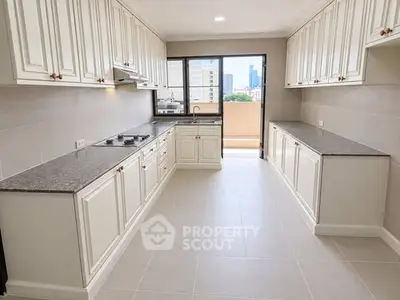 Spacious kitchen with closed layout and modern appliances in a high-rise apartment.