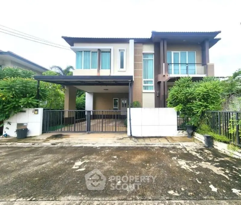 Modern two-story house with lush greenery and spacious driveway