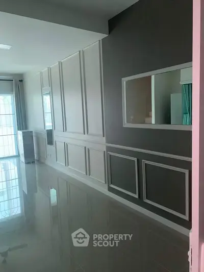 Elegant modern interior with large windows and stylish wall paneling, perfect for a chic living space.
