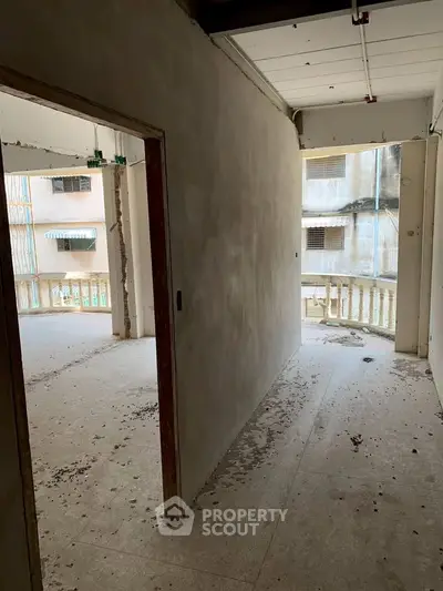 Spacious unfinished apartment hallway with balcony view