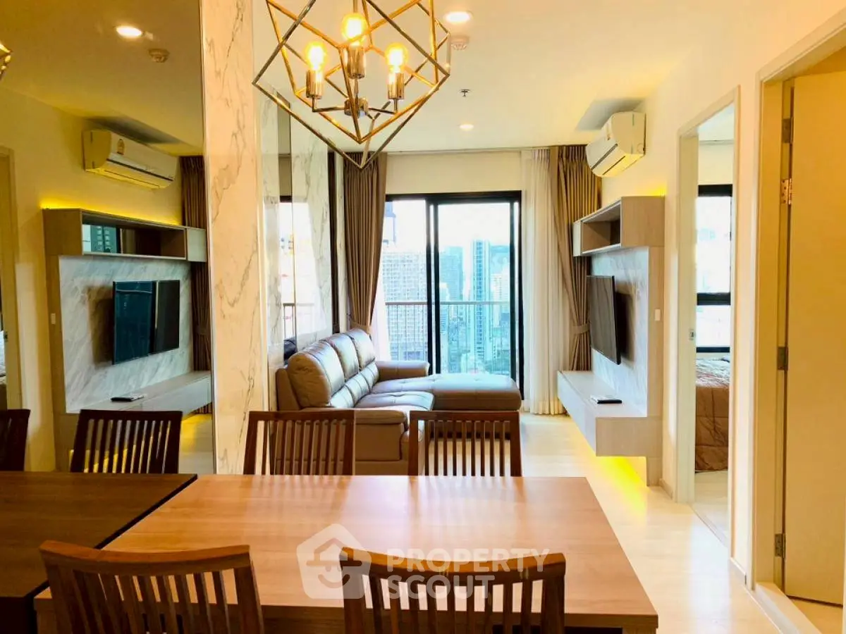 Modern living room with city view, stylish furniture, and elegant lighting in a high-rise apartment.