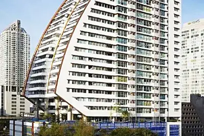 Modern architectural high-rise building with unique design in urban cityscape.
