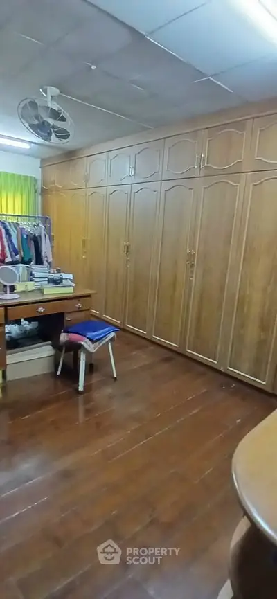 Spacious storage room with wooden cabinets and hardwood flooring