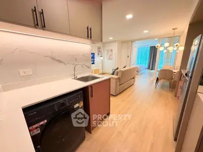 Modern open-plan kitchen and living area with stylish decor and natural light.
