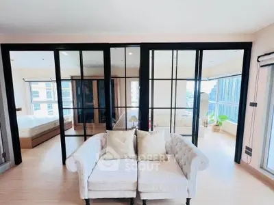 Spacious modern living room with elegant glass doors and cozy sofa, offering a bright and airy ambiance.