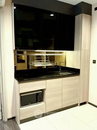 Modern kitchen with sleek cabinetry and built-in microwave, featuring a stylish open layout.