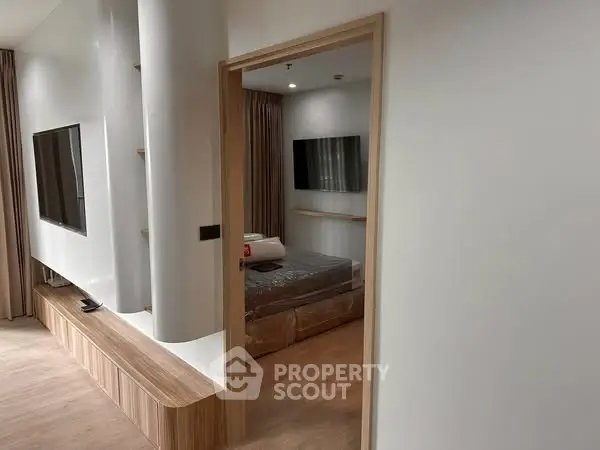 Modern apartment interior with sleek living room and cozy bedroom view.