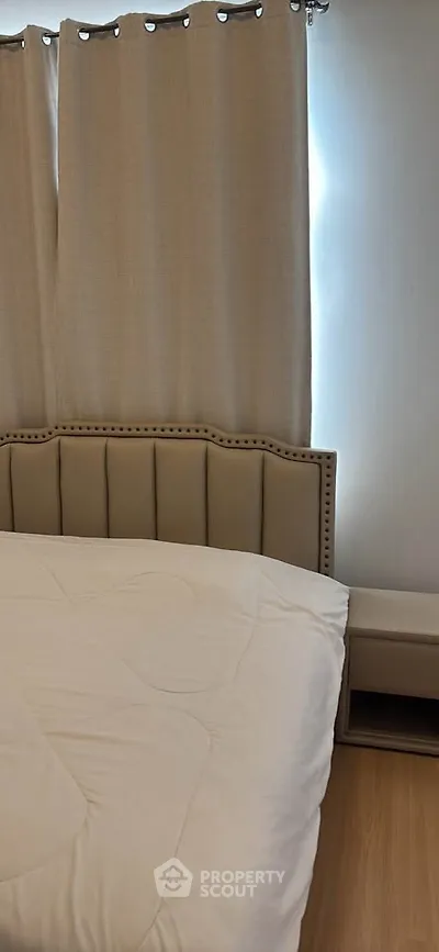 Cozy bedroom with elegant bed and neutral curtains, perfect for relaxation.