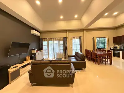 Spacious living room with modern furniture and open dining area, perfect for family gatherings.