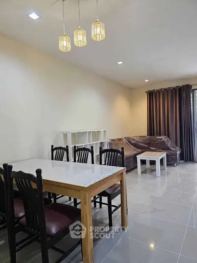 Spacious living room with modern dining set and cozy seating area, perfect for family gatherings.