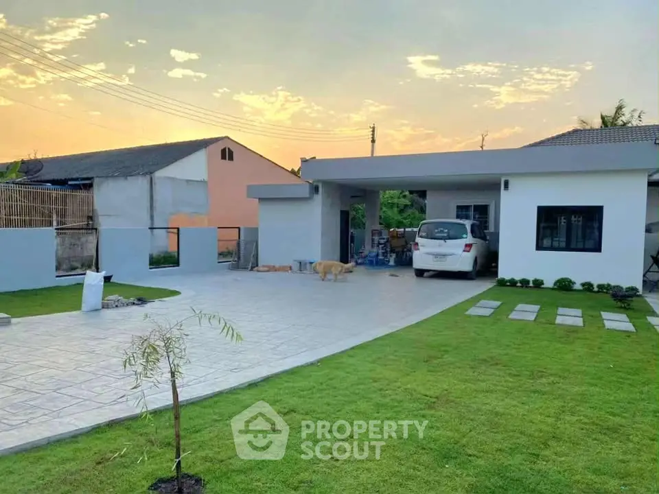 Charming suburban home with spacious driveway and lush green lawn at sunset.