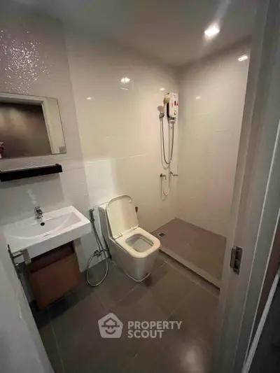 Modern bathroom with sleek fixtures and walk-in shower in a contemporary apartment.