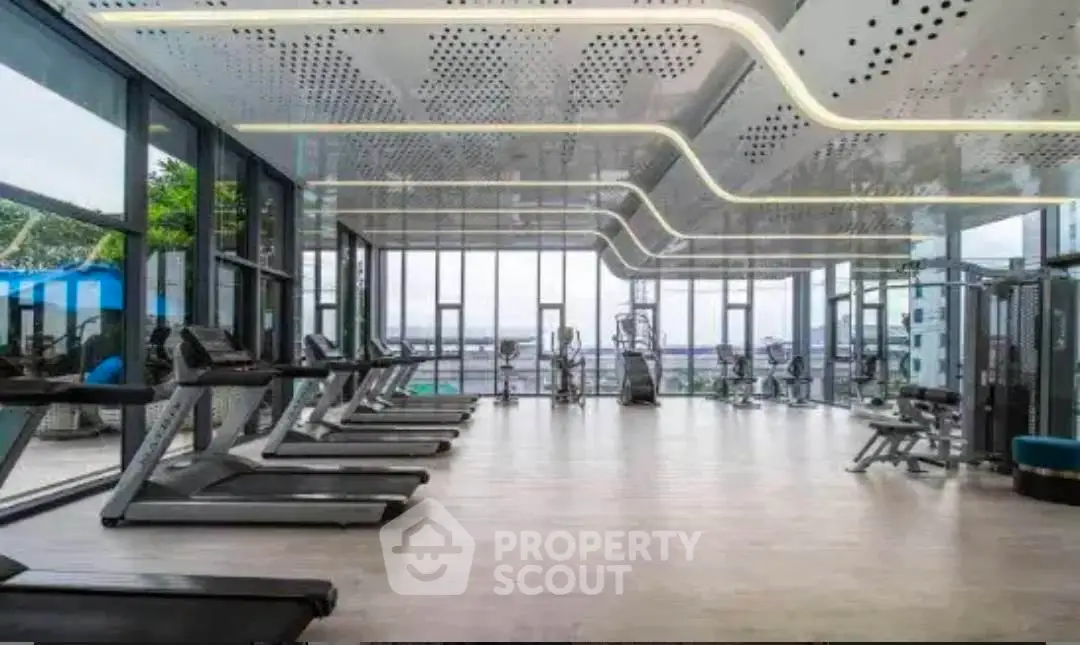 Luxurious modern gym with panoramic windows and state-of-the-art equipment in a high-end residential building.