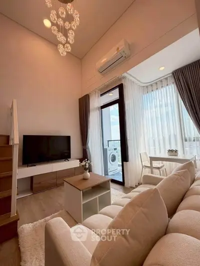 Modern living room with high ceiling, elegant chandelier, and large windows offering stunning views.