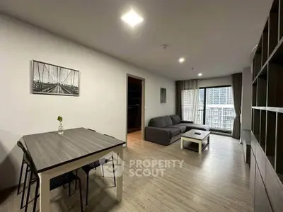 Modern living room with stylish furniture and large windows offering city views.