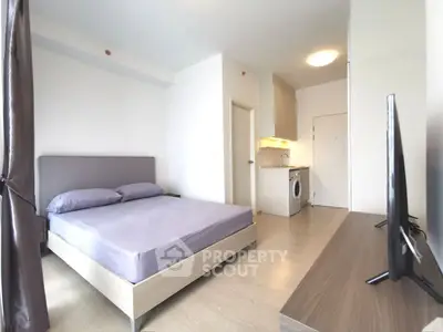 Modern studio apartment with bed, kitchenette, and washing machine