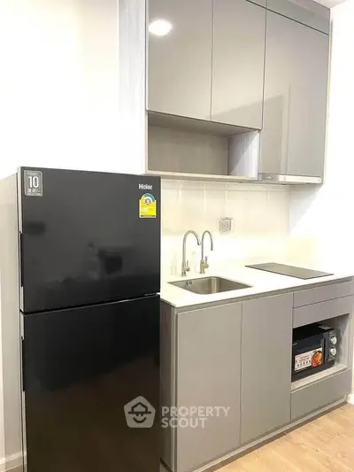 Modern kitchen with sleek cabinetry and appliances in a compact layout.