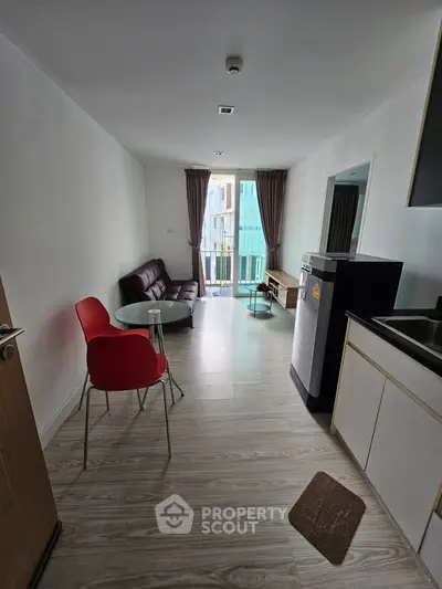Modern living room with balcony access and stylish furniture in a bright apartment.