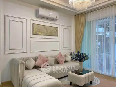 Elegant living room with plush sofa, chic decor, and large window for natural light.